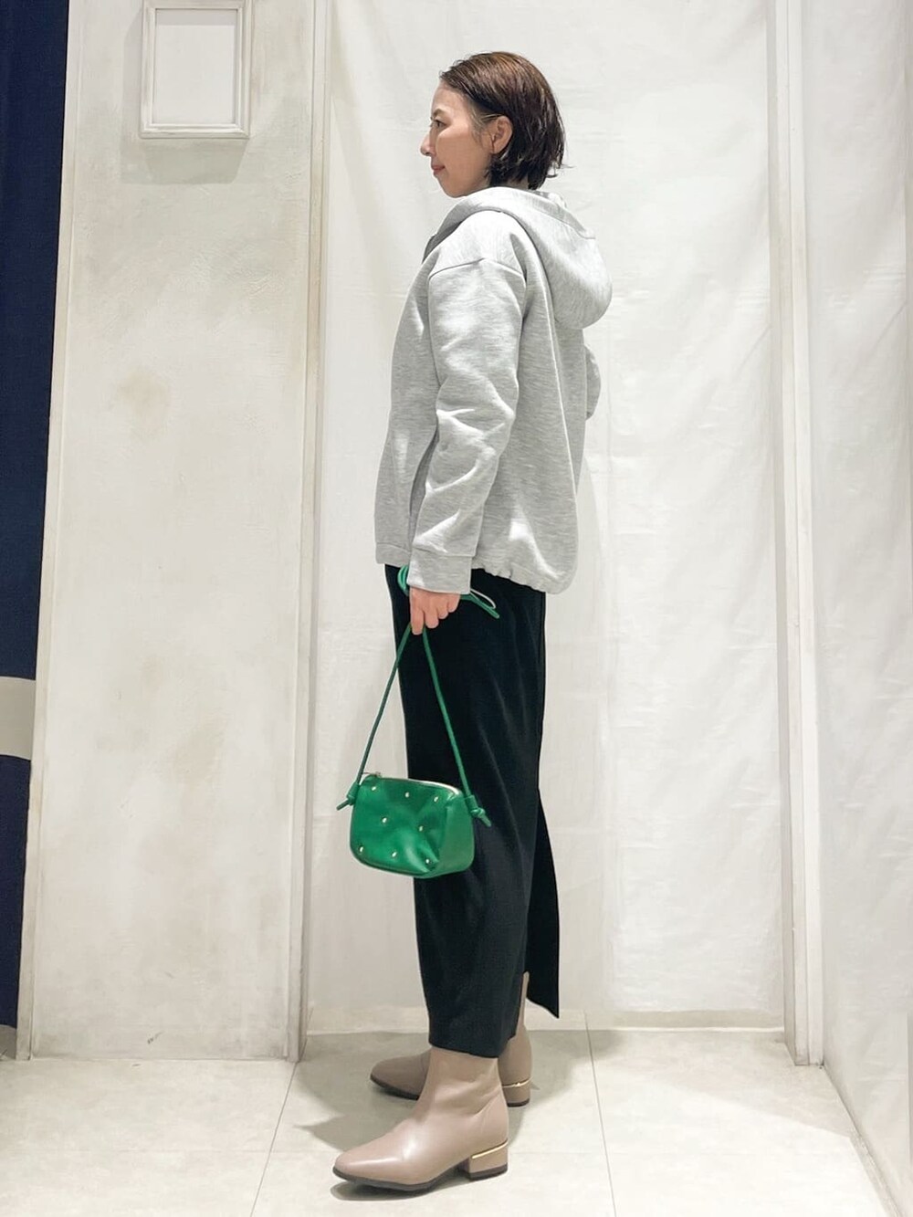 グレー系のブルゾン、ホワイト系のニット/セーター、ホワイト系のTシャツ/カットソーを着用したレディースの冬コーディネートの3枚目の写真