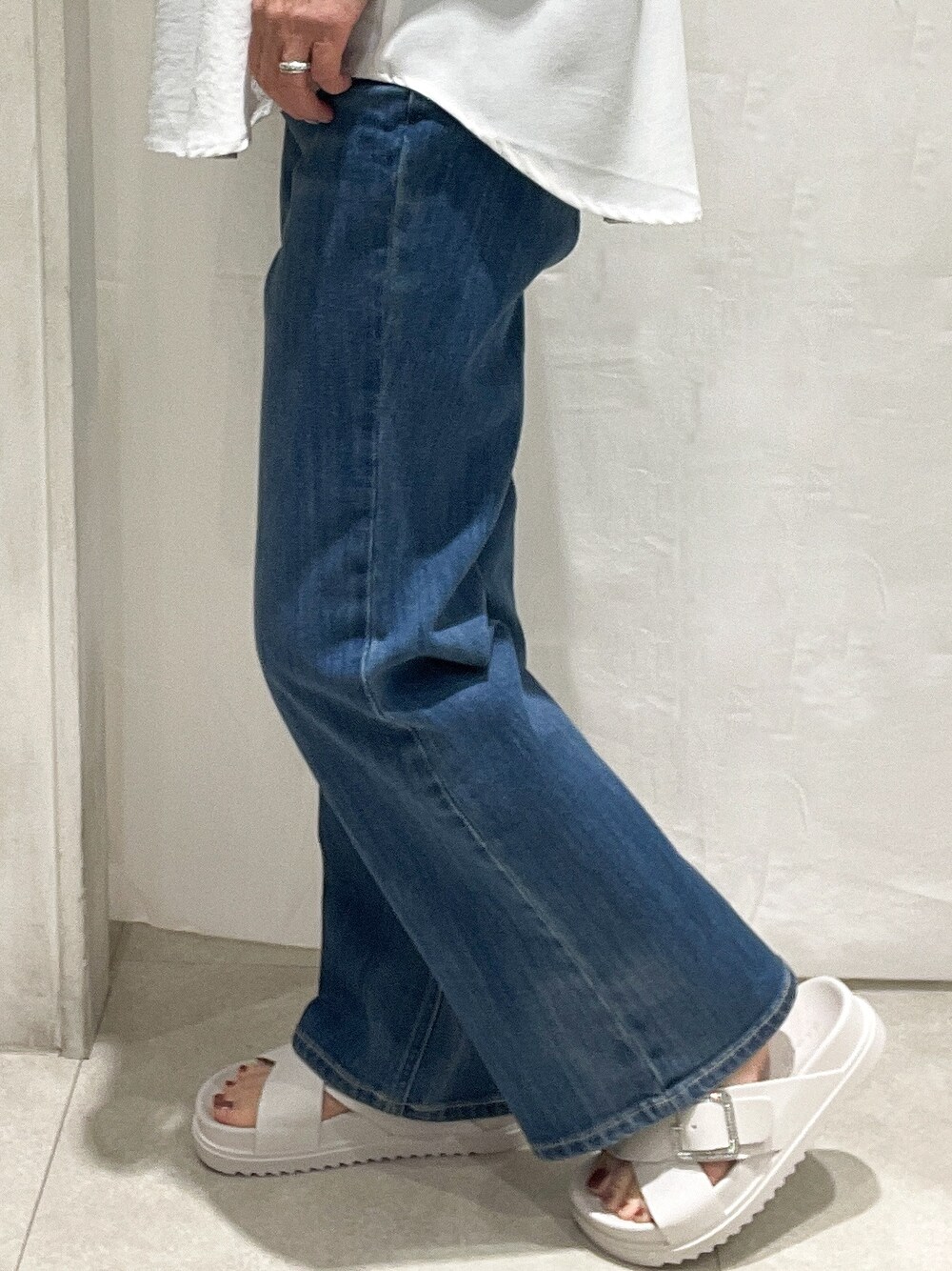 ホワイト系のシャツ/ブラウス、ブラック系のタンクトップ、ブルー系のデニムパンツを着用したレディースの夏コーディネートの4枚目の写真