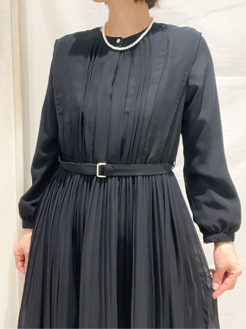 ブルー系のノーカラージャケット、ブラック系のワンピース、ベージュ系のショルダーバッグを着用したレディースの冬コーディネートの5枚目の写真