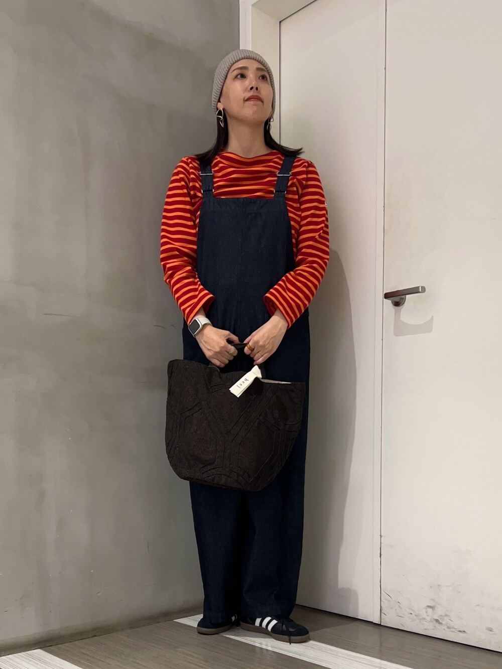 ブルー系のサロペット/オーバーオール、ブラック系のスニーカー、レッド系のTシャツ/カットソーを着用したレディースの秋コーディネートの3枚目の写真