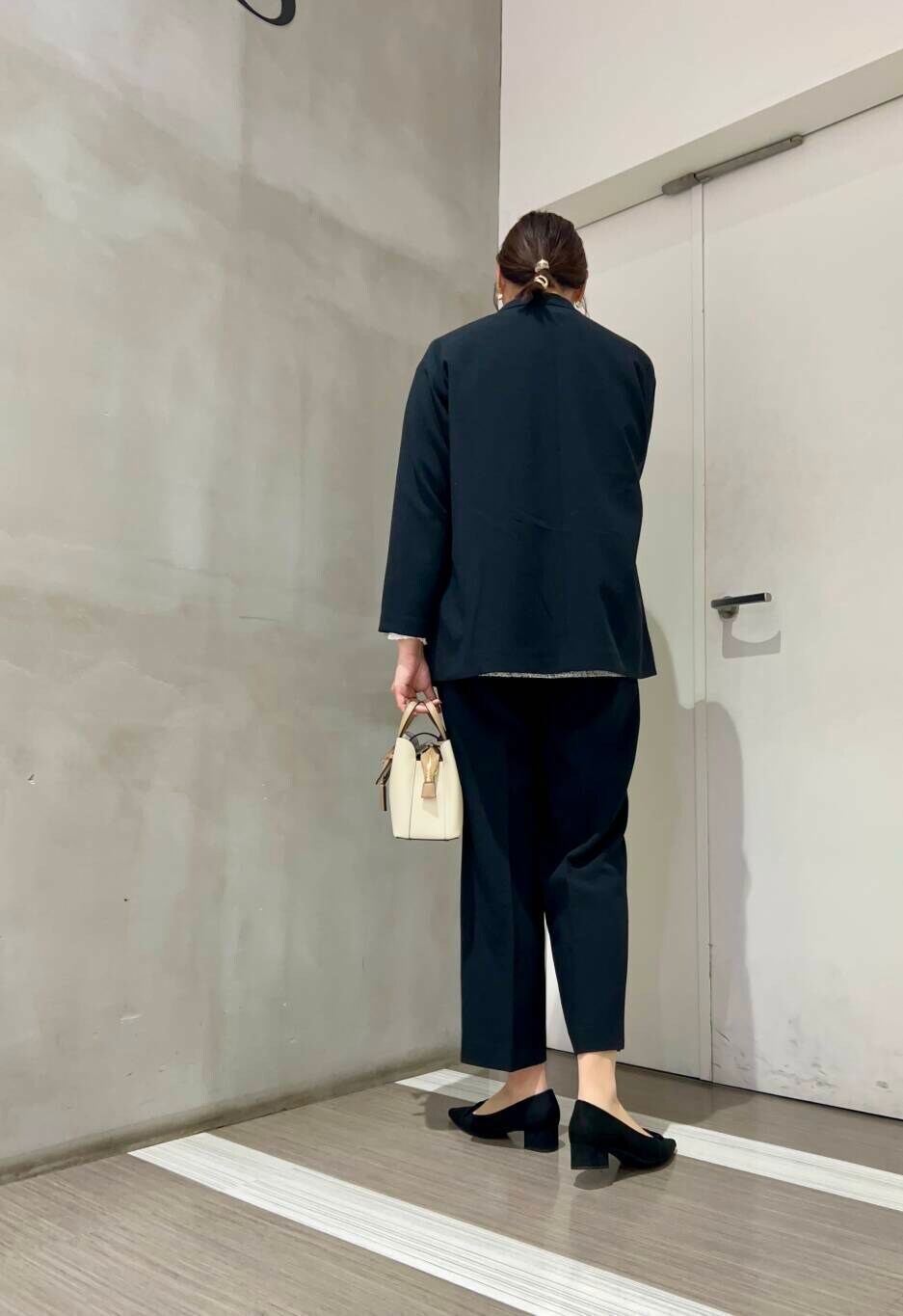 ホワイト系のハンドバッグ、ホワイト系のシャツ/ブラウス、ブラック系のパンプスを着用したレディースの冬コーディネートの7枚目の写真