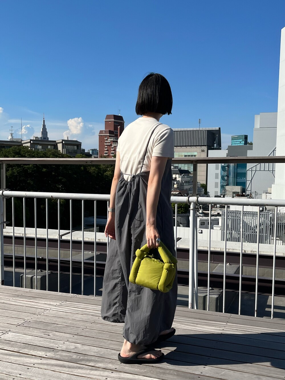 グリーン系のトートバッグを着用したレディースの夏コーディネートの2枚目の写真