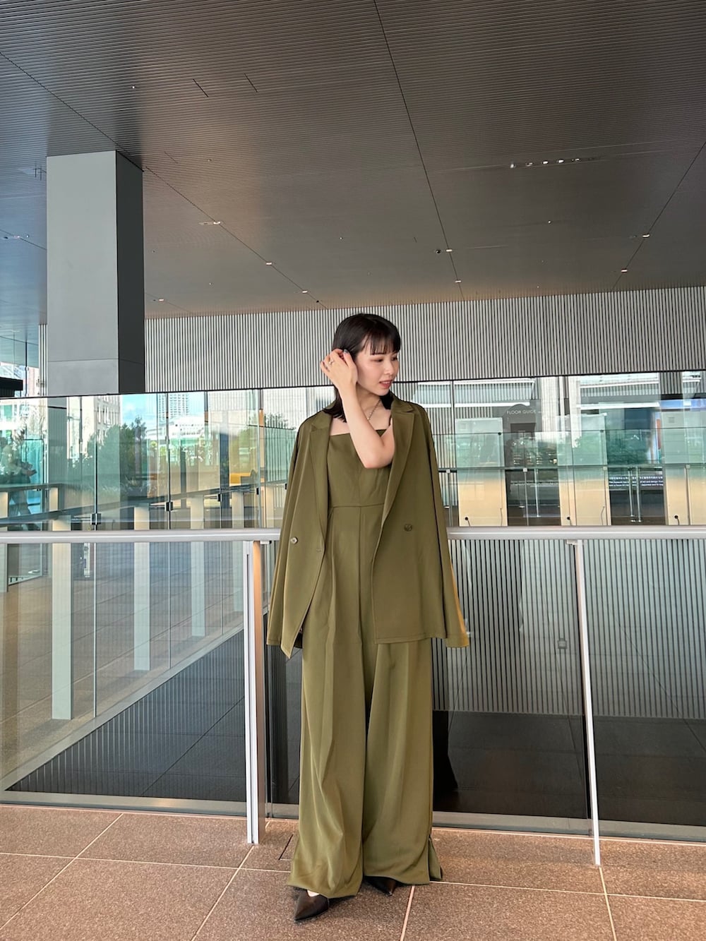 グリーン系のパンツドレスを着用したレディースの秋コーディネートの3枚目の写真