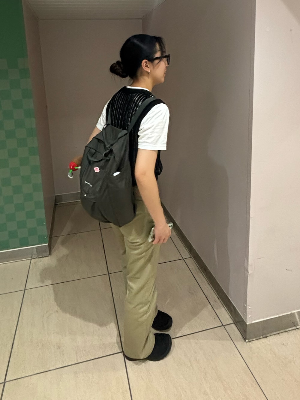 ブラウン系のチノパンツ、ブラック系のベスト、グレー系のバックパック/リュックを着用したレディースの夏コーディネートの4枚目の写真