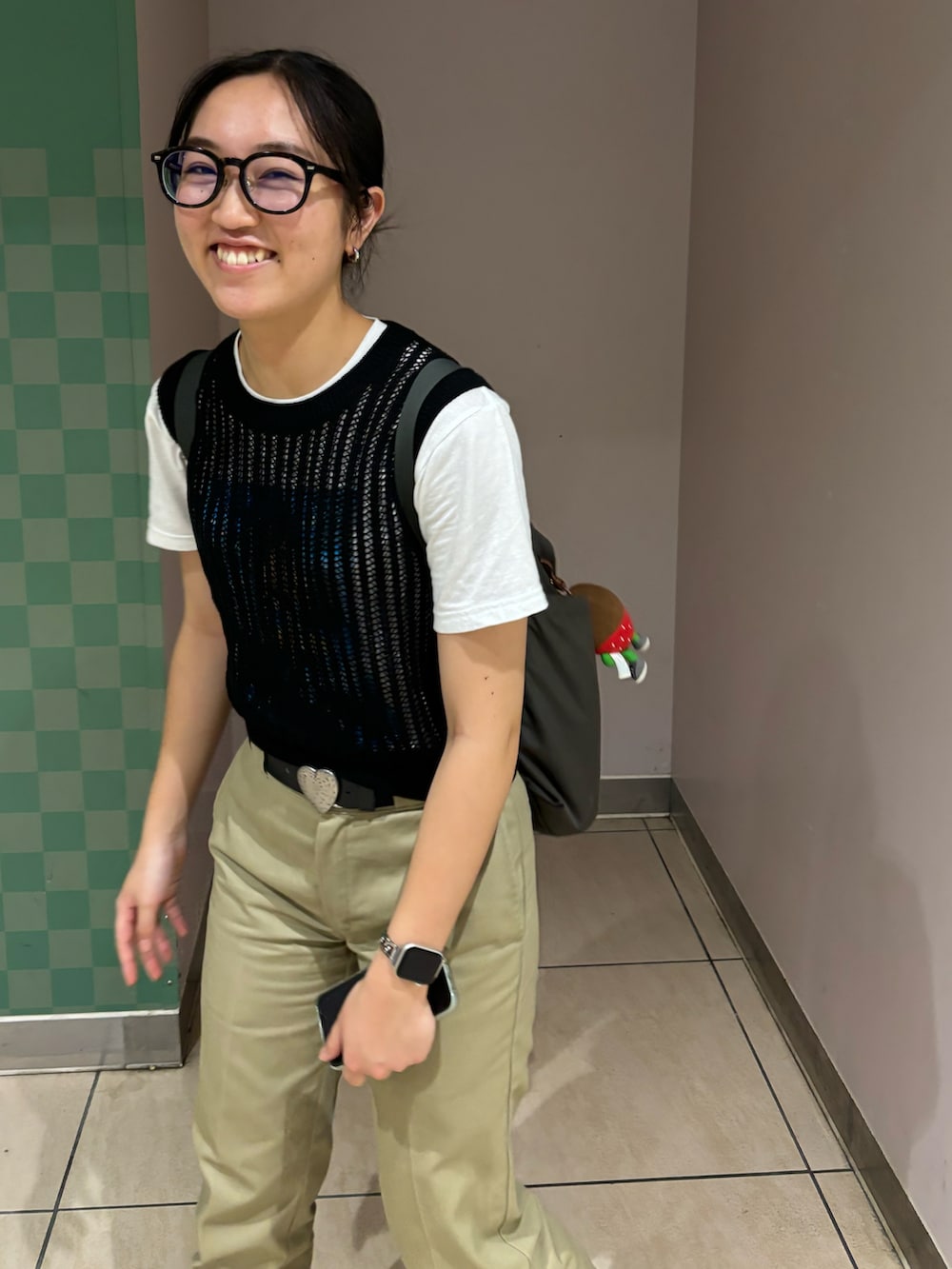 ブラウン系のチノパンツ、ブラック系のベスト、グレー系のバックパック/リュックを着用したレディースの夏コーディネートの2枚目の写真