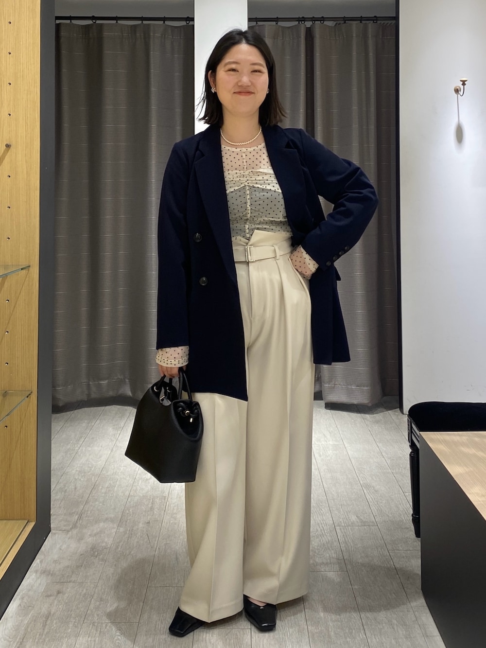ベージュ系のシャツ/ブラウス、ブルー系のテーラードジャケット、ブラック系のショルダーバッグを着用したレディースの冬コーディネートの5枚目の写真