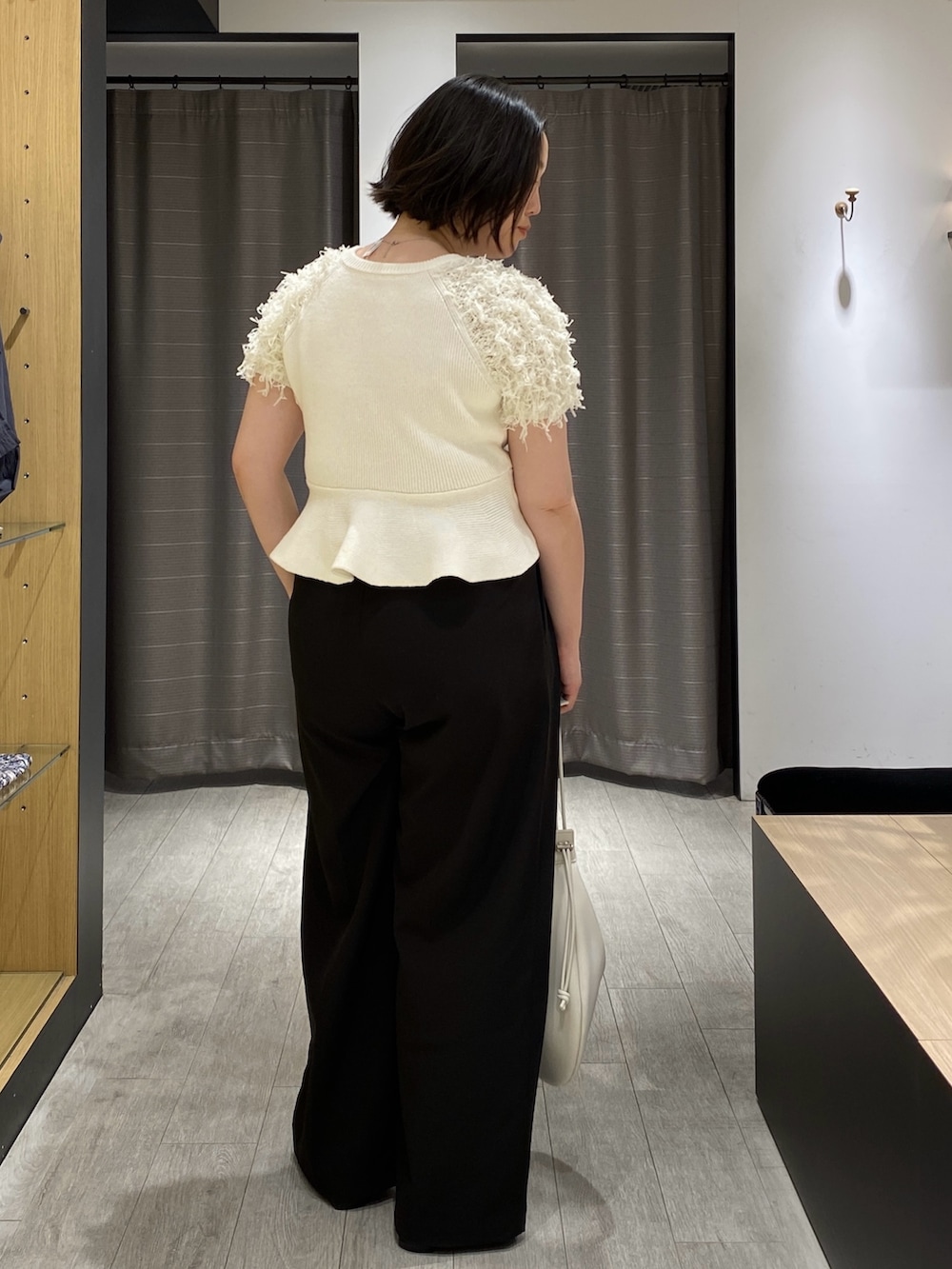 ホワイト系のニット/セーター、ブラック系のその他パンツ、ブラック系のローファーを着用したレディースの春コーディネートの6枚目の写真