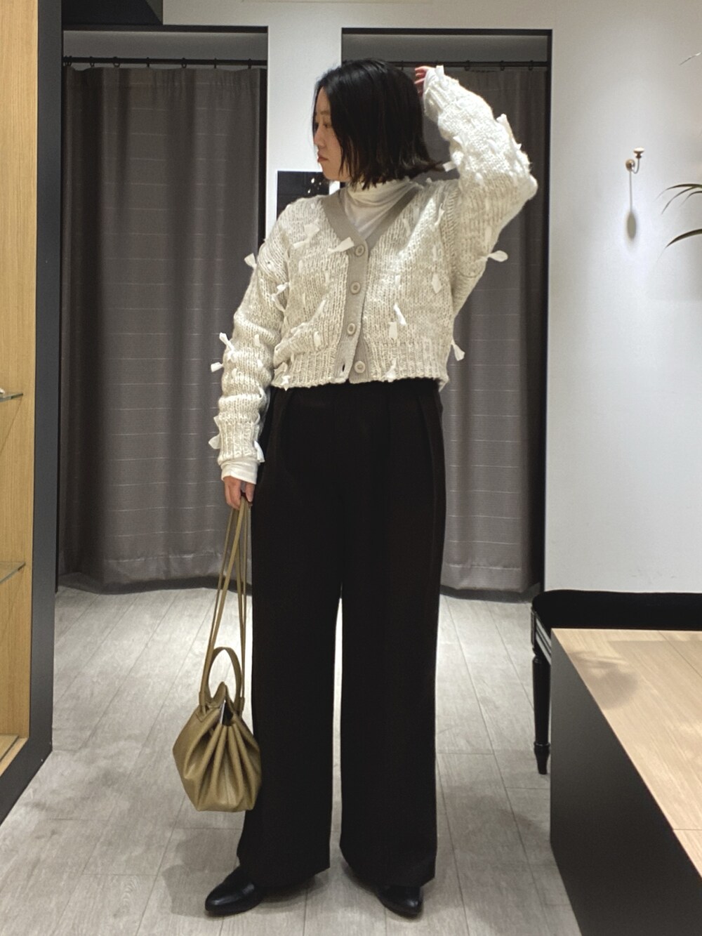 ブラック系のブーツ、ブラック系のその他パンツ、ホワイト系のカーディガン/ボレロを着用したレディースの冬コーディネートの6枚目の写真