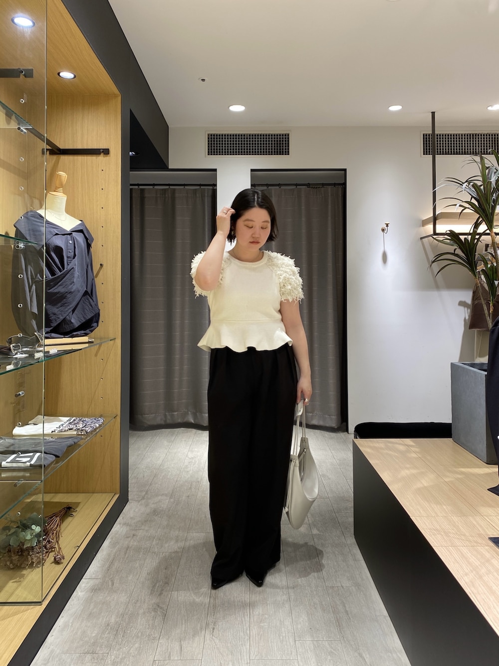 ホワイト系のニット/セーター、ブラック系のその他パンツ、ブラック系のローファーを着用したレディースの春コーディネートの2枚目の写真