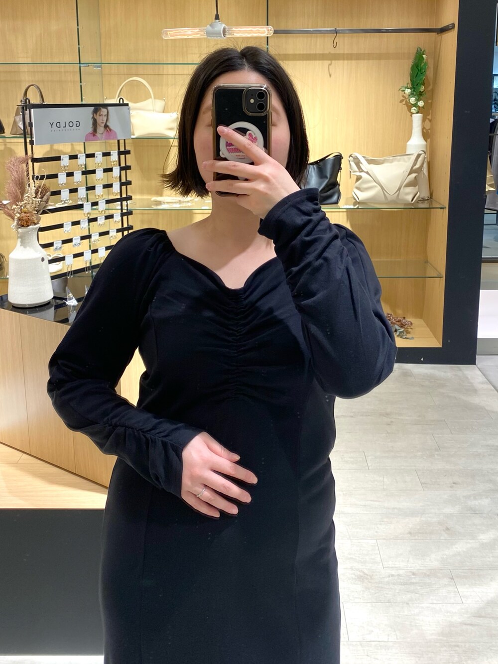 ブラック系のワンピース、ブラック系のパンプスを着用したレディースの春コーディネートの2枚目の写真