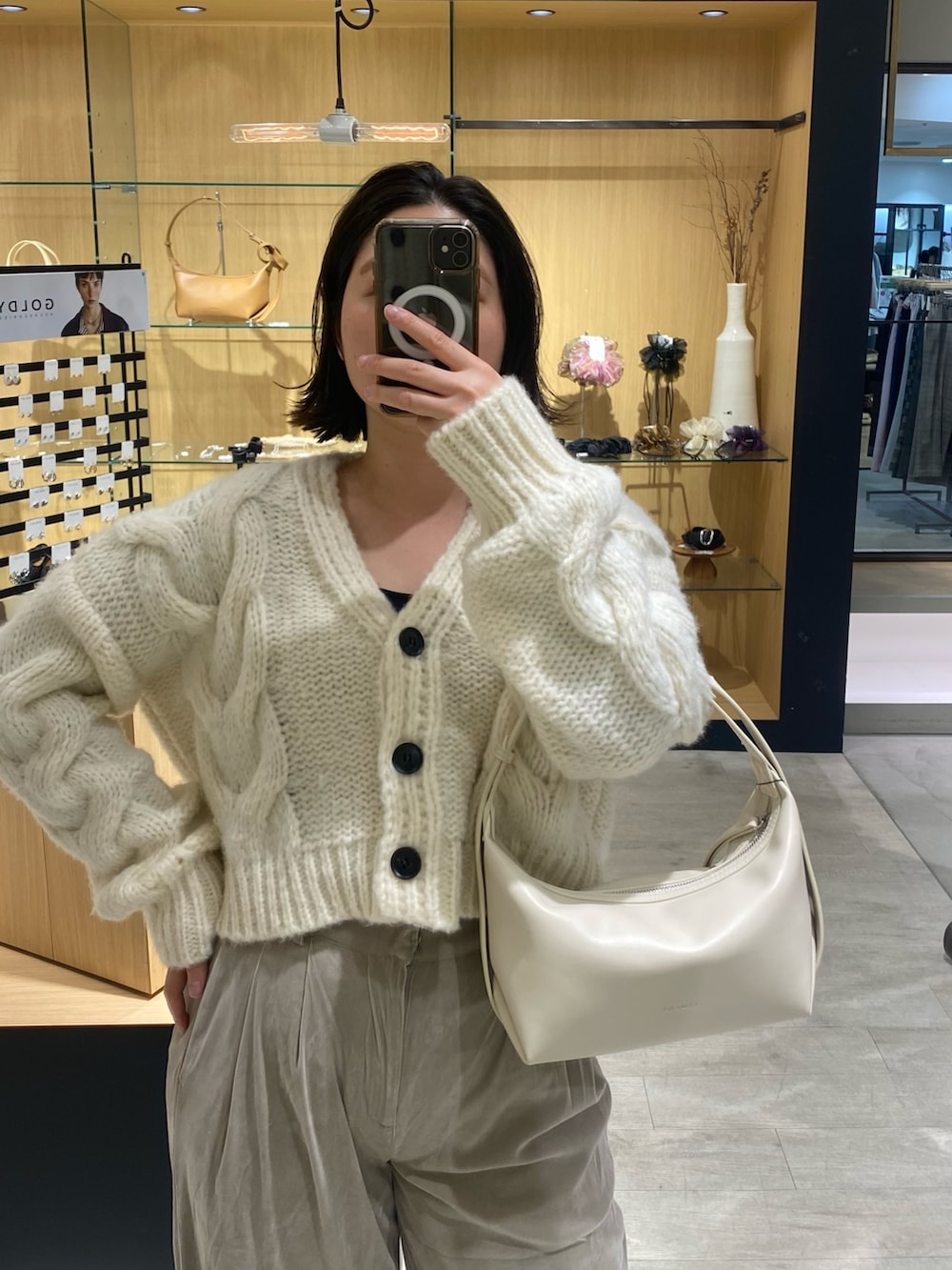 ホワイト系のカーディガン/ボレロ、ベージュ系のその他パンツ、ホワイト系のショルダーバッグを着用したレディースの冬コーディネートの3枚目の写真