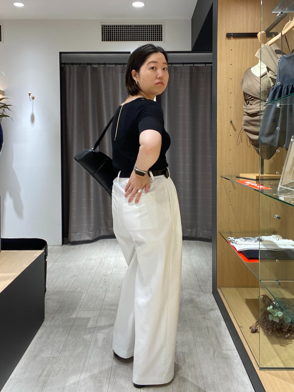 ブラック系のニット/セーター、ブラック系のショルダーバッグ、ホワイト系のその他パンツを着用したレディースの夏コーディネートの6枚目の写真