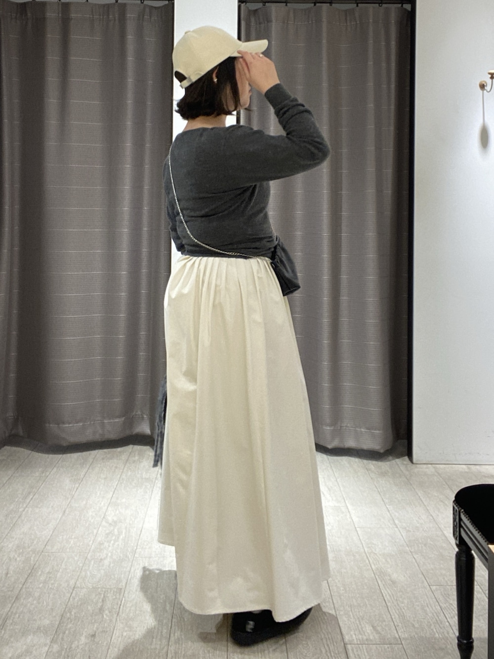 ブラック系のスニーカー、グレー系のニット/セーター、ブラック系のショルダーバッグを着用したレディースの冬コーディネートの6枚目の写真