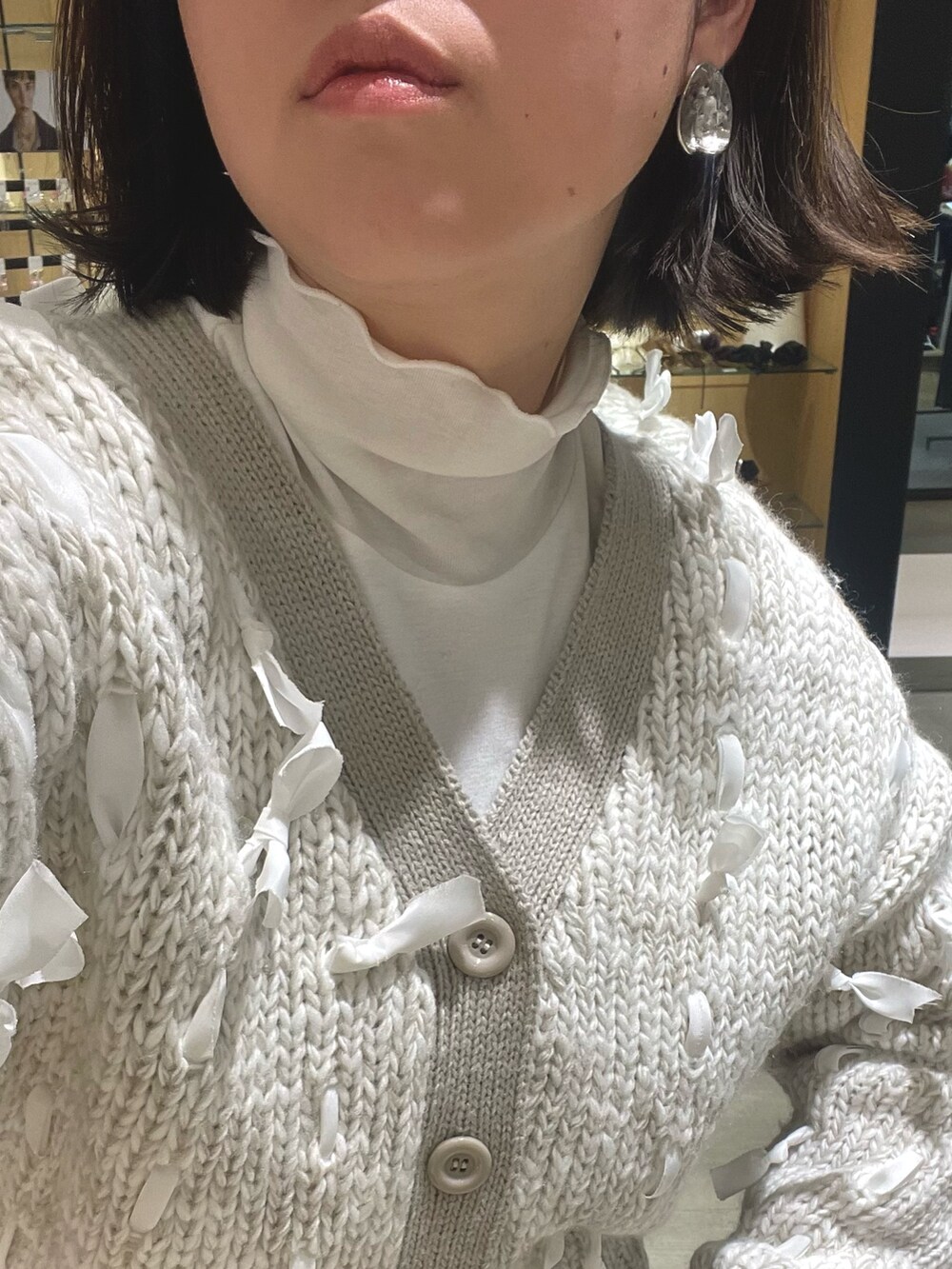 ブラック系のブーツ、ブラック系のその他パンツ、ホワイト系のカーディガン/ボレロを着用したレディースの冬コーディネートの4枚目の写真