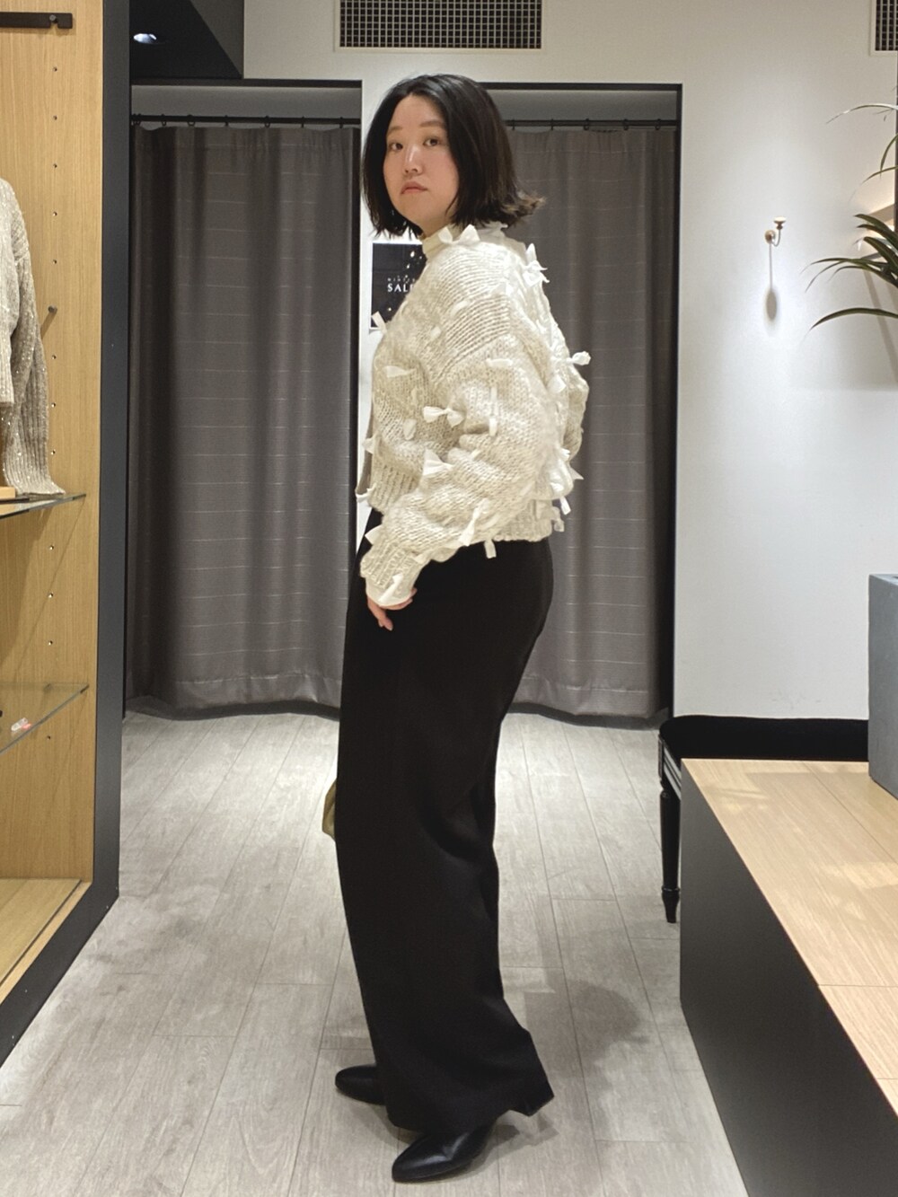 ブラック系のブーツ、ブラック系のその他パンツ、ホワイト系のカーディガン/ボレロを着用したレディースの冬コーディネートの8枚目の写真