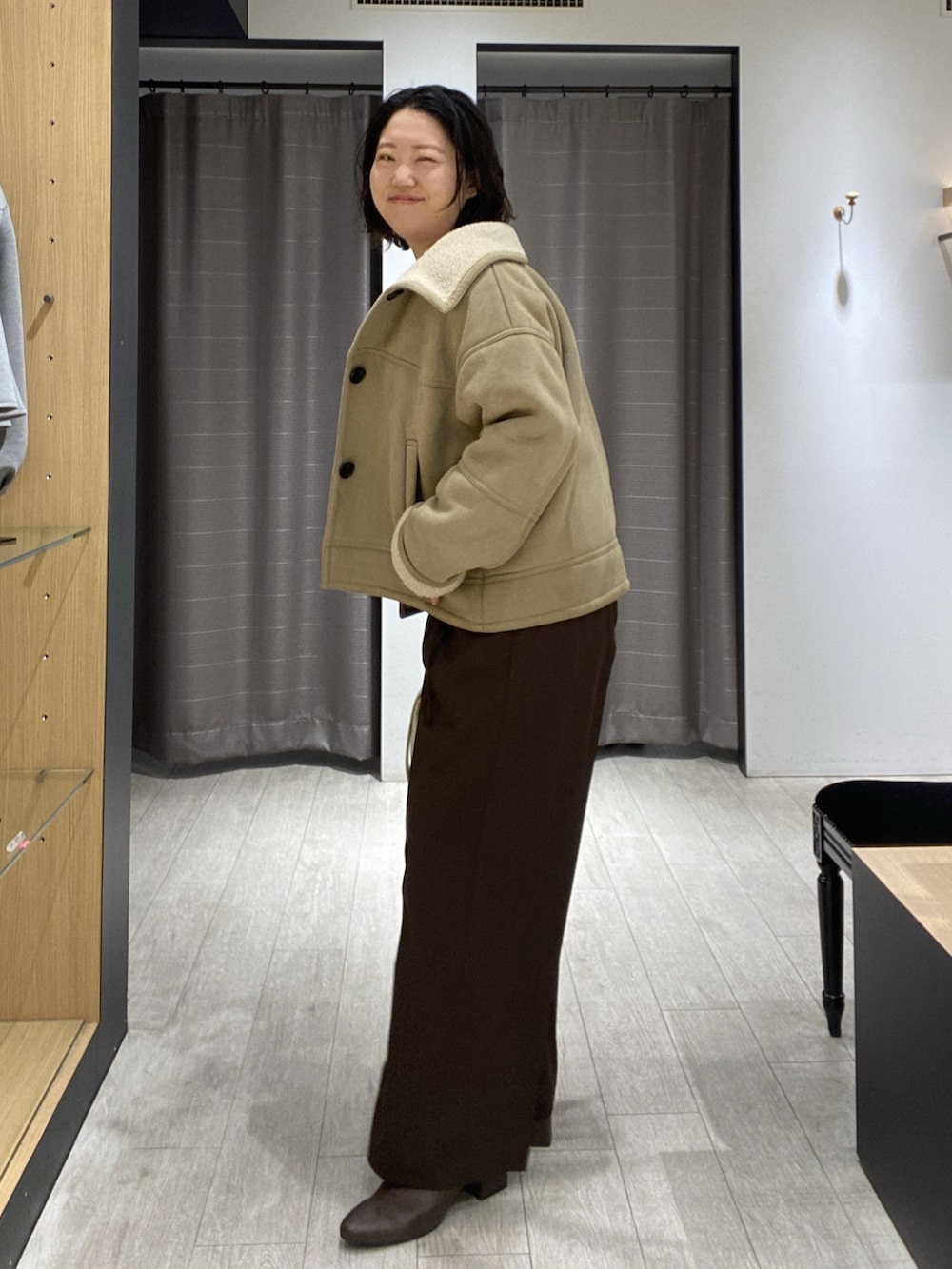 ベージュ系のその他アウター、ホワイト系のニット/セーター、ホワイト系のショルダーバッグを着用したレディースの秋コーディネートの3枚目の写真