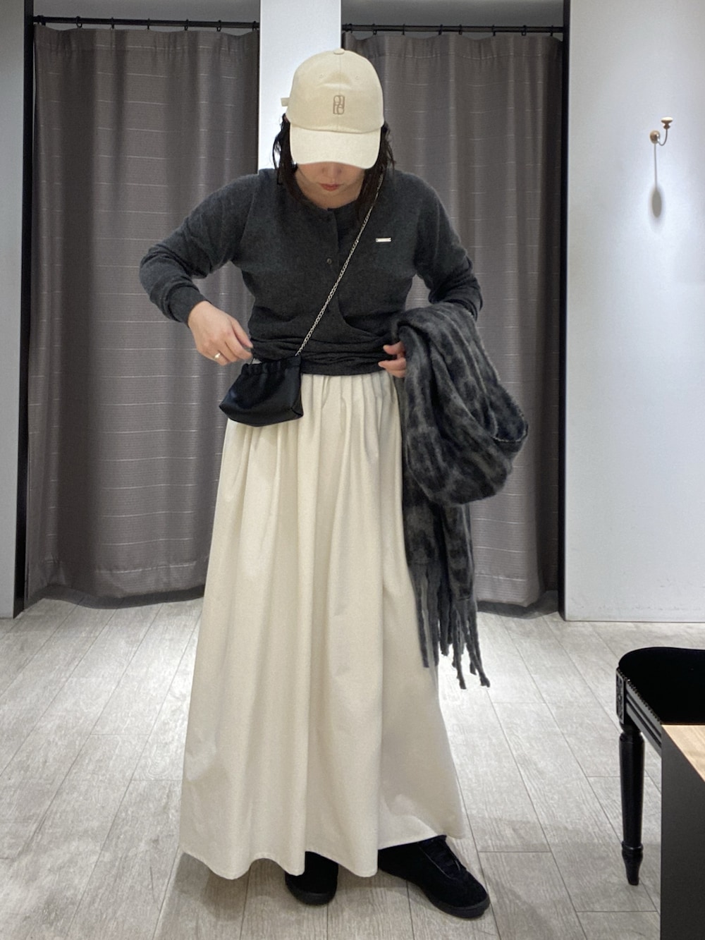 ブラック系のスニーカー、グレー系のニット/セーター、ブラック系のショルダーバッグを着用したレディースの冬コーディネートの2枚目の写真