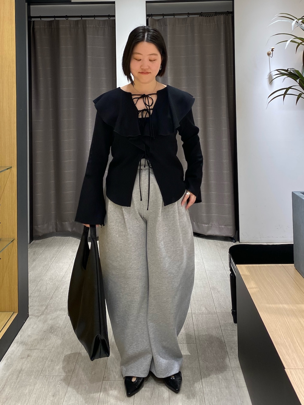 ブラック系のシャツ/ブラウス、グレー系のその他パンツ、ブラック系のパンプスを着用したレディースの春コーディネートの2枚目の写真