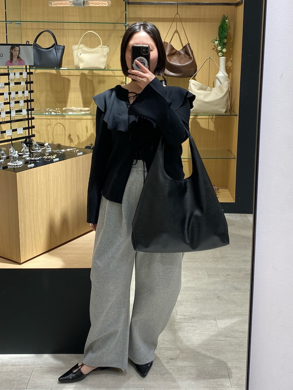 ブラック系のシャツ/ブラウス、グレー系のその他パンツ、ブラック系のパンプスを着用したレディースの春コーディネートの4枚目の写真