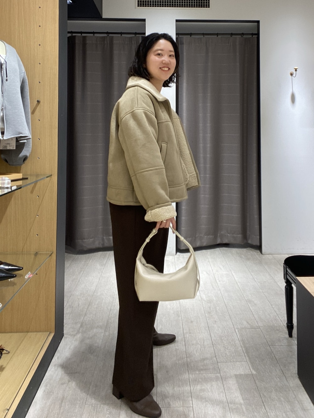 ベージュ系のその他アウター、ホワイト系のニット/セーター、ホワイト系のショルダーバッグを着用したレディースの秋コーディネートの7枚目の写真