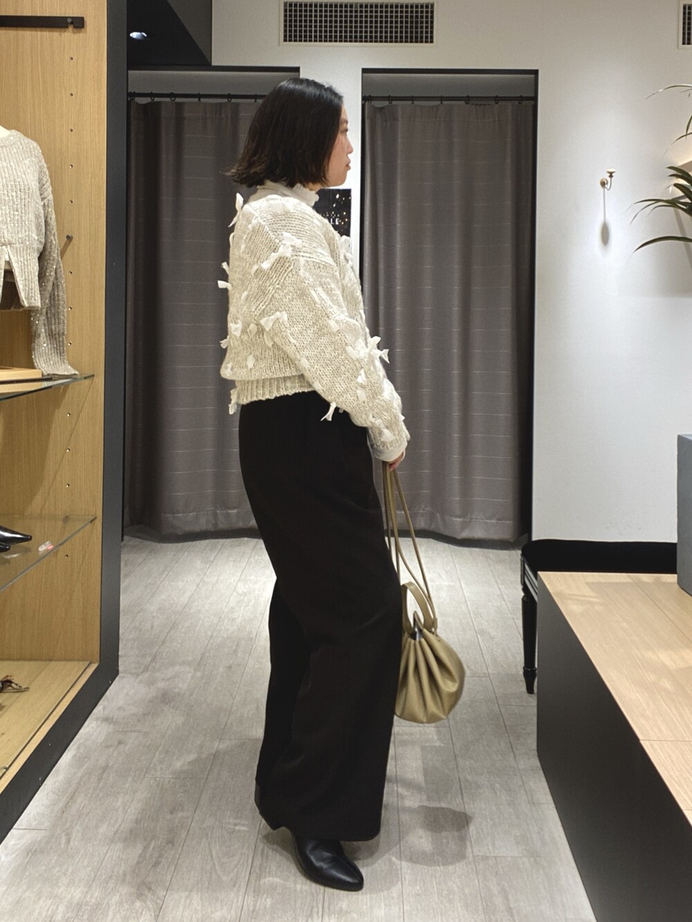 ブラック系のブーツ、ブラック系のその他パンツ、ホワイト系のカーディガン/ボレロを着用したレディースの冬コーディネートの9枚目の写真