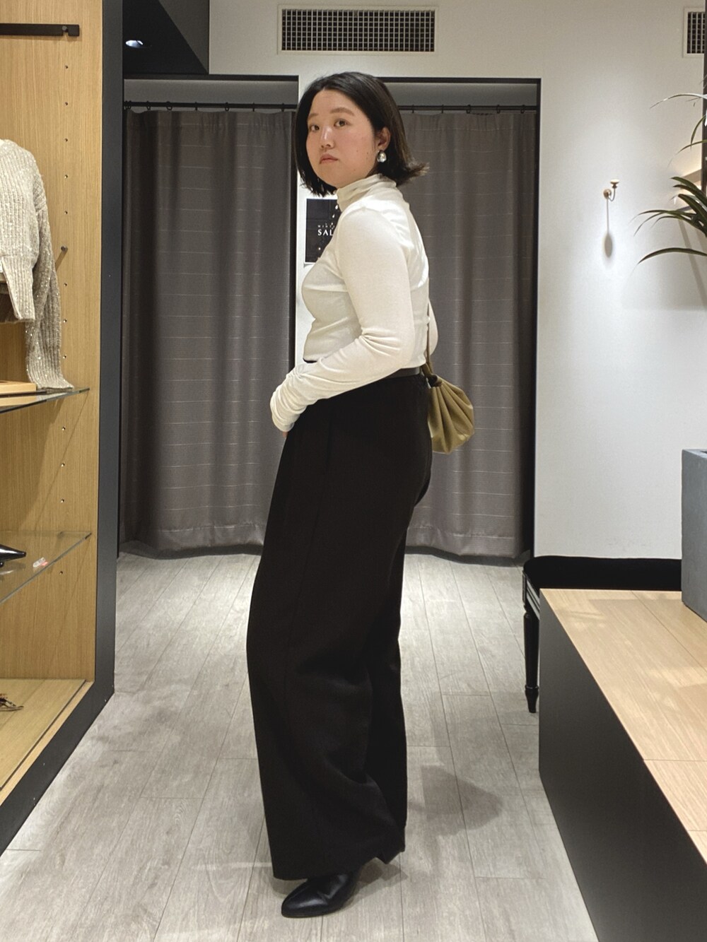 ブラック系のブーツ、ブラック系のその他パンツ、ホワイト系のカーディガン/ボレロを着用したレディースの冬コーディネートの10枚目の写真