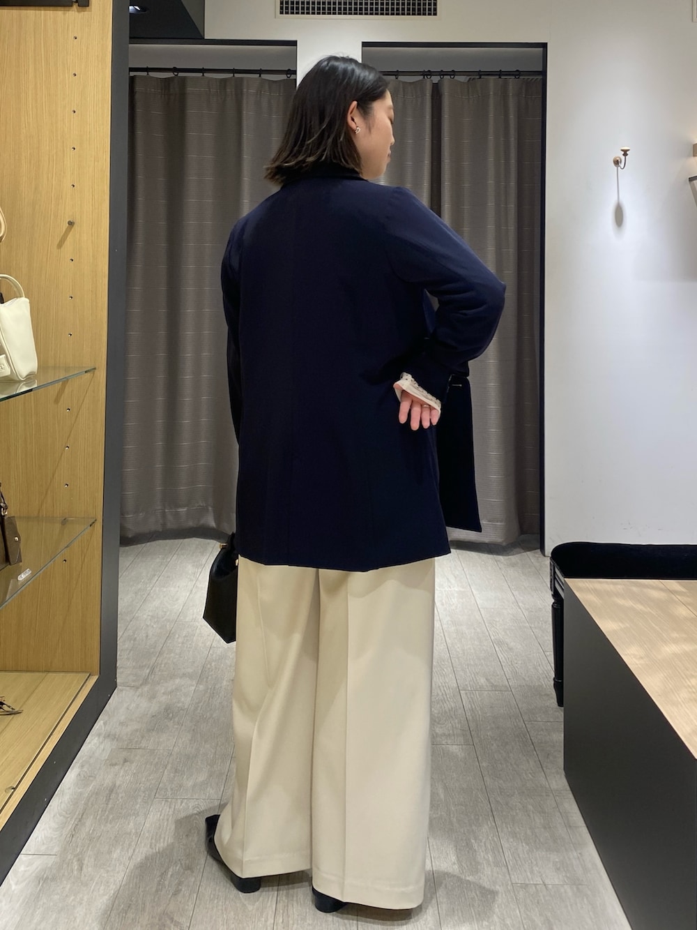 ベージュ系のシャツ/ブラウス、ブルー系のテーラードジャケット、ブラック系のショルダーバッグを着用したレディースの冬コーディネートの7枚目の写真