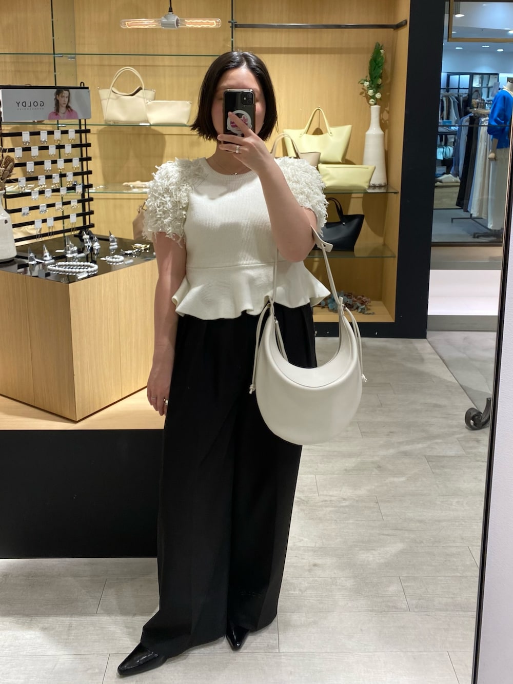 ホワイト系のニット/セーター、ブラック系のその他パンツ、ブラック系のローファーを着用したレディースの春コーディネートの4枚目の写真