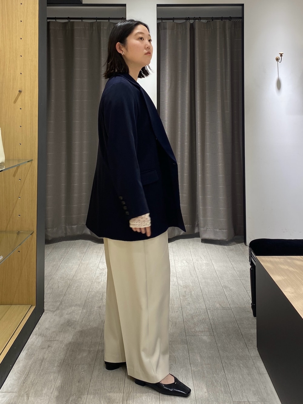 ベージュ系のシャツ/ブラウス、ブルー系のテーラードジャケット、ブラック系のショルダーバッグを着用したレディースの冬コーディネートの6枚目の写真