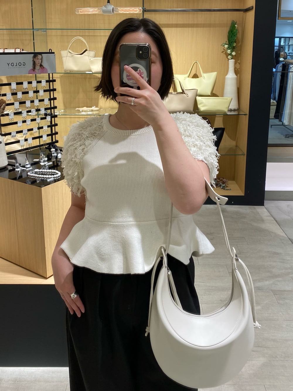 ホワイト系のニット/セーター、ブラック系のその他パンツ、ブラック系のローファーを着用したレディースの春コーディネートの3枚目の写真