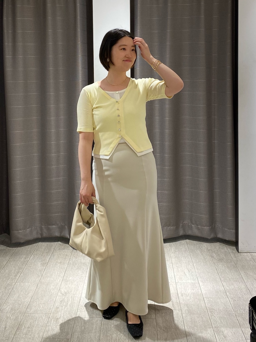 ブラック系のパンプス、イエロー系のTシャツ/カットソー、ホワイト系のショルダーバッグを着用したレディースの夏コーディネートの2枚目の写真
