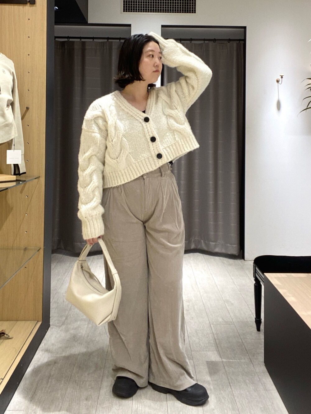 ホワイト系のカーディガン/ボレロ、ベージュ系のその他パンツ、ホワイト系のショルダーバッグを着用したレディースの冬コーディネートの2枚目の写真