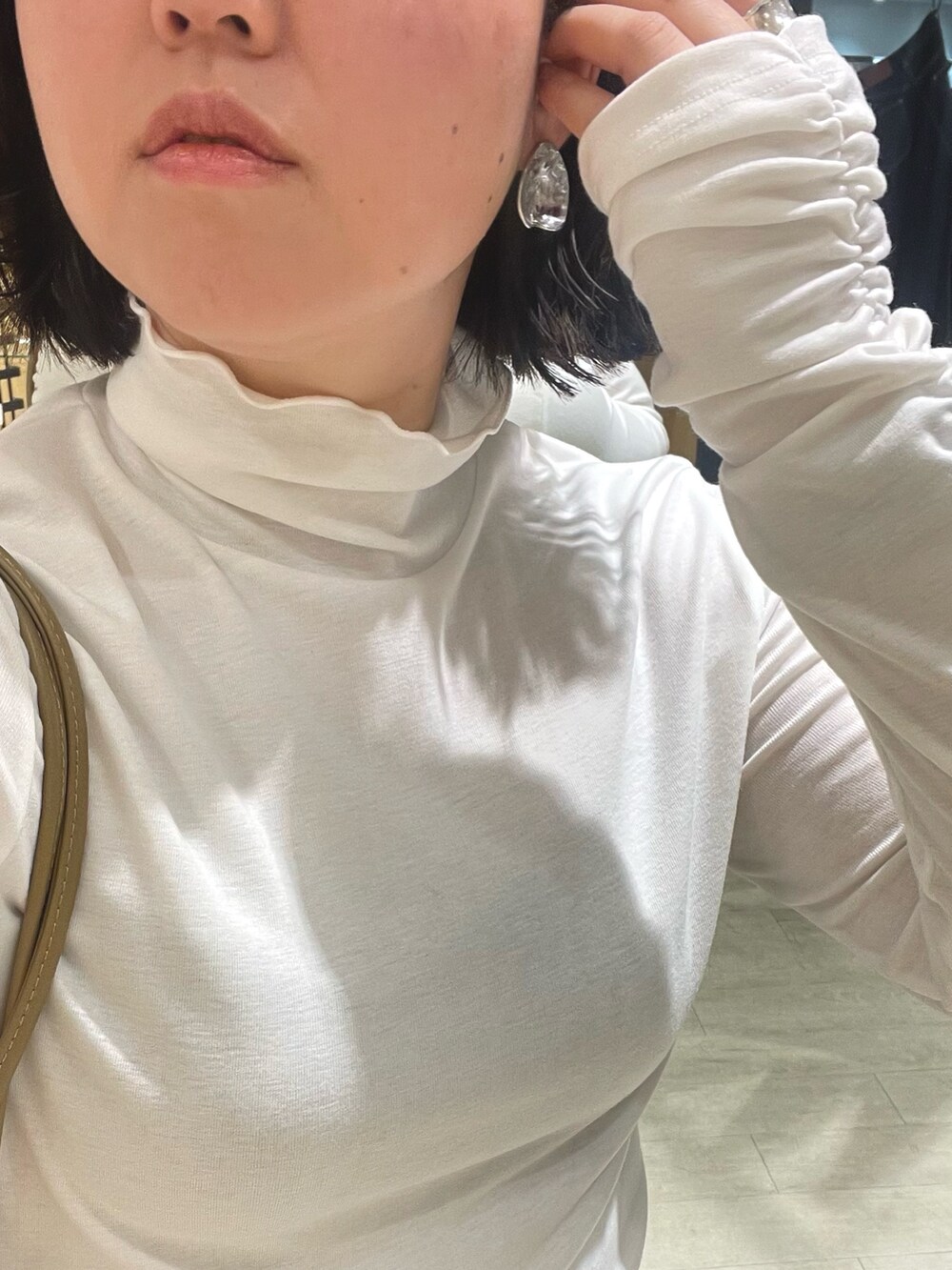 ブラック系のブーツ、ブラック系のその他パンツ、ホワイト系のカーディガン/ボレロを着用したレディースの冬コーディネートの5枚目の写真