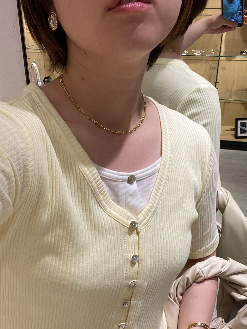 ブラック系のパンプス、イエロー系のTシャツ/カットソー、ホワイト系のショルダーバッグを着用したレディースの夏コーディネートの4枚目の写真