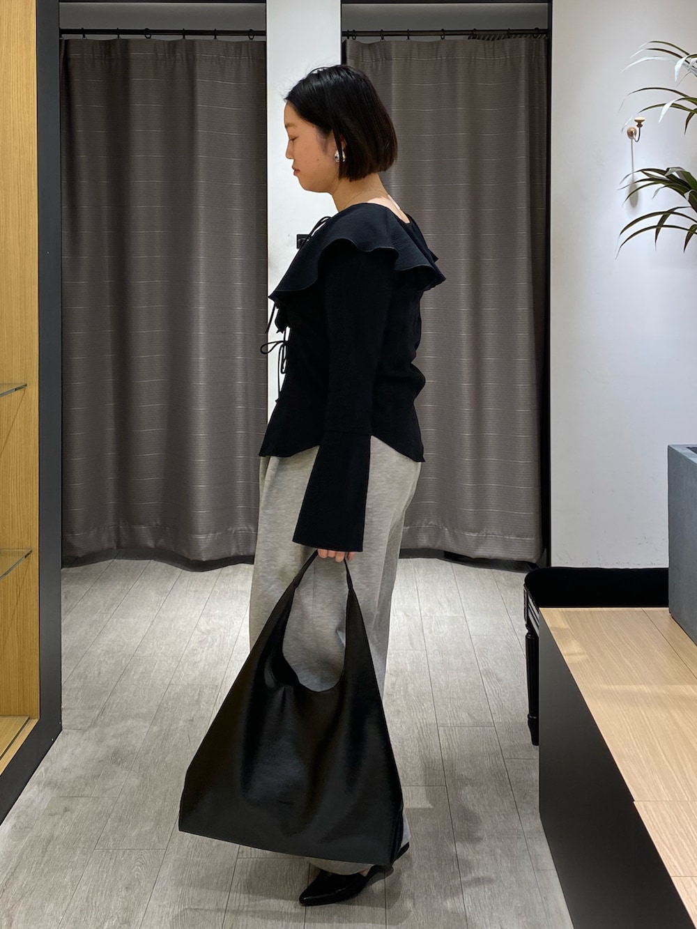 ブラック系のシャツ/ブラウス、グレー系のその他パンツ、ブラック系のパンプスを着用したレディースの春コーディネートの6枚目の写真