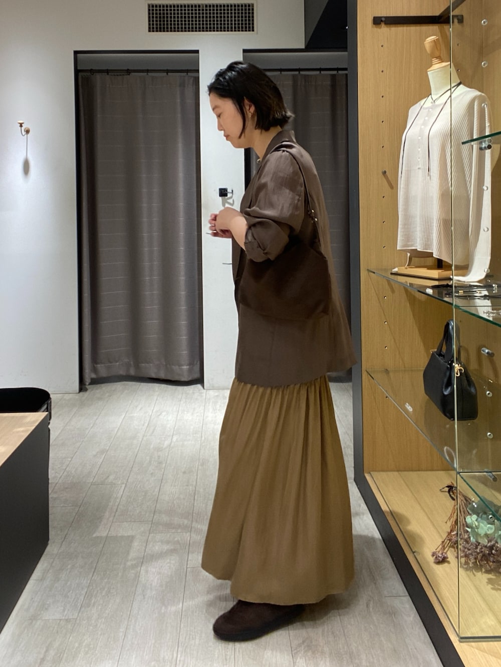 ブラウン系のニット/セーター、ブラウン系のショルダーバッグ、ブラウン系のスニーカーを着用したレディースの秋コーディネートの7枚目の写真