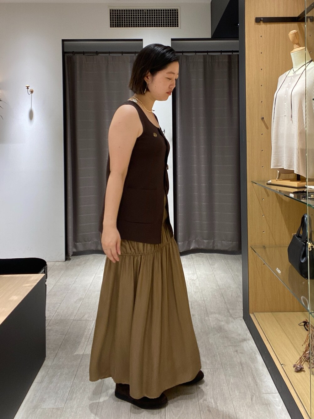 ブラウン系のニット/セーター、ブラウン系のショルダーバッグ、ブラウン系のスニーカーを着用したレディースの秋コーディネートの9枚目の写真
