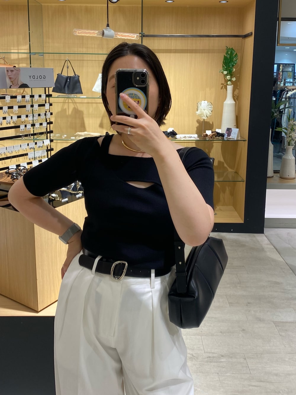 ブラック系のニット/セーター、ブラック系のショルダーバッグ、ホワイト系のその他パンツを着用したレディースの夏コーディネートの3枚目の写真