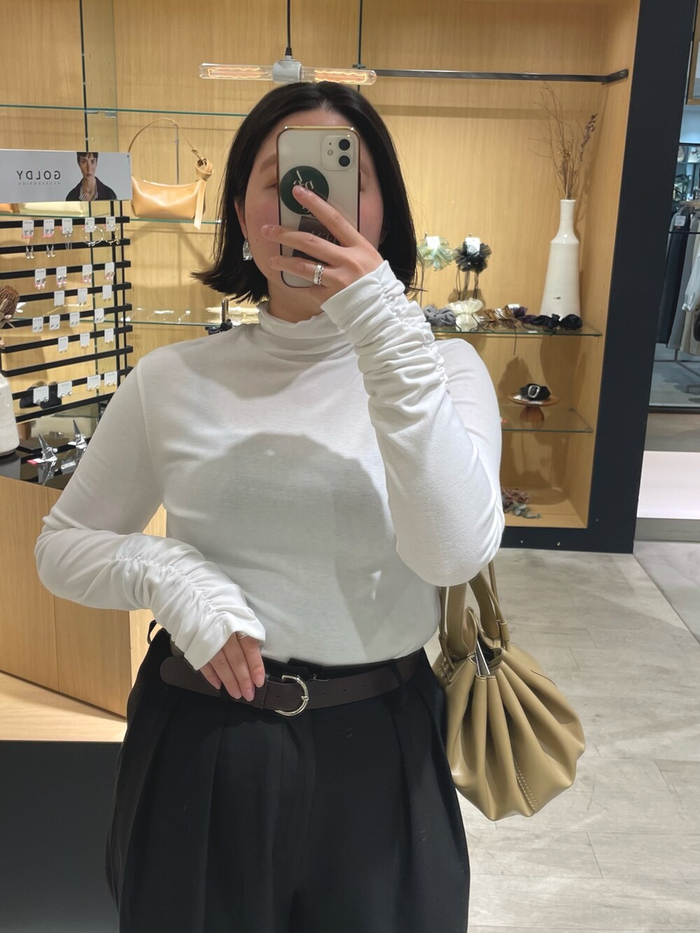 ブラック系のブーツ、ブラック系のその他パンツ、ホワイト系のカーディガン/ボレロを着用したレディースの冬コーディネートの3枚目の写真