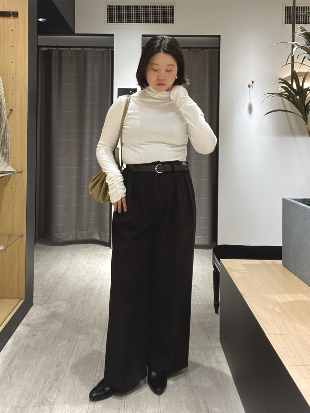 ブラック系のブーツ、ブラック系のその他パンツ、ホワイト系のカーディガン/ボレロを着用したレディースの冬コーディネートの7枚目の写真