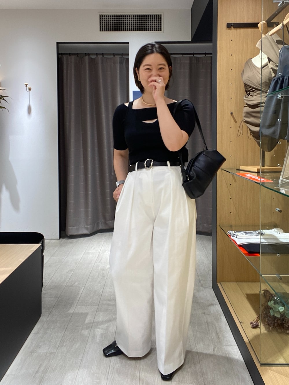 ブラック系のニット/セーター、ブラック系のショルダーバッグ、ホワイト系のその他パンツを着用したレディースの夏コーディネートの2枚目の写真