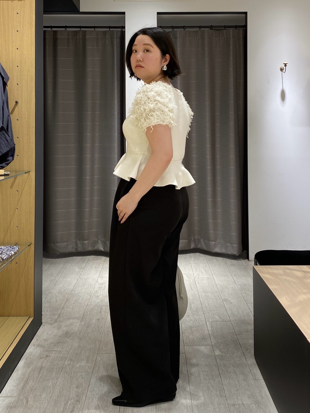 ホワイト系のニット/セーター、ブラック系のその他パンツ、ブラック系のローファーを着用したレディースの春コーディネートの5枚目の写真