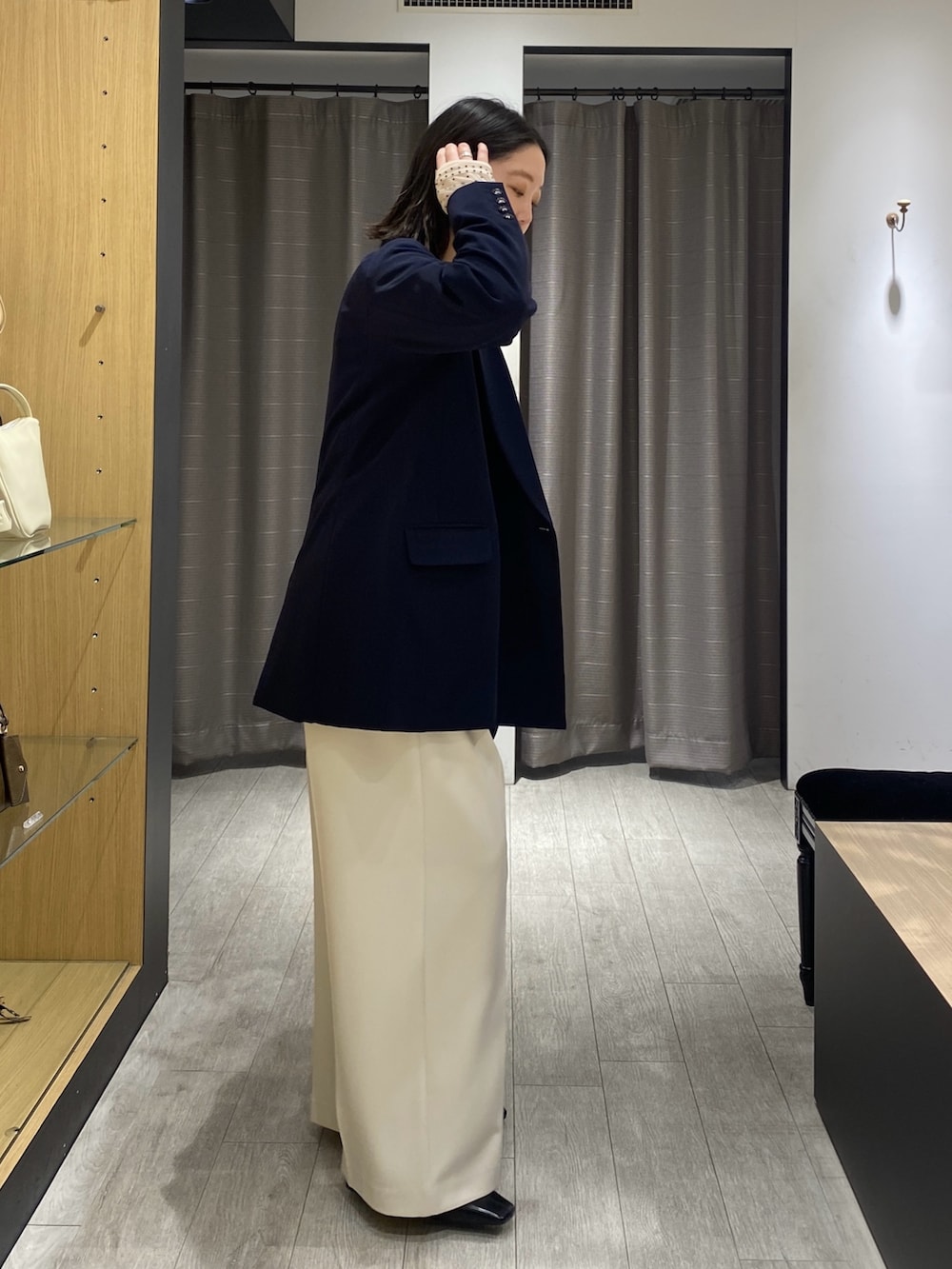 ベージュ系のシャツ/ブラウス、ブルー系のテーラードジャケット、ブラック系のショルダーバッグを着用したレディースの冬コーディネートの4枚目の写真