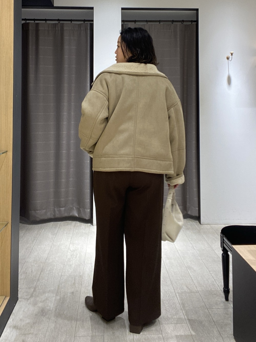 ベージュ系のその他アウター、ホワイト系のニット/セーター、ホワイト系のショルダーバッグを着用したレディースの秋コーディネートの5枚目の写真