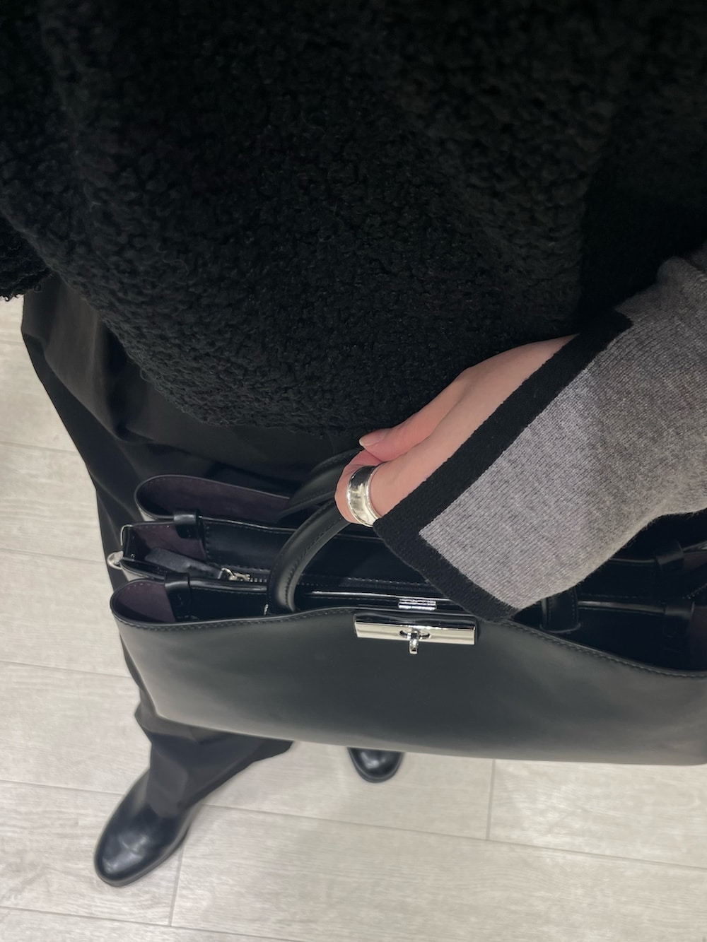 グレー系のニット/セーター、ブラック系のブーツ、ブラック系のシャツ/ブラウスを着用したレディースの冬コーディネートの3枚目の写真
