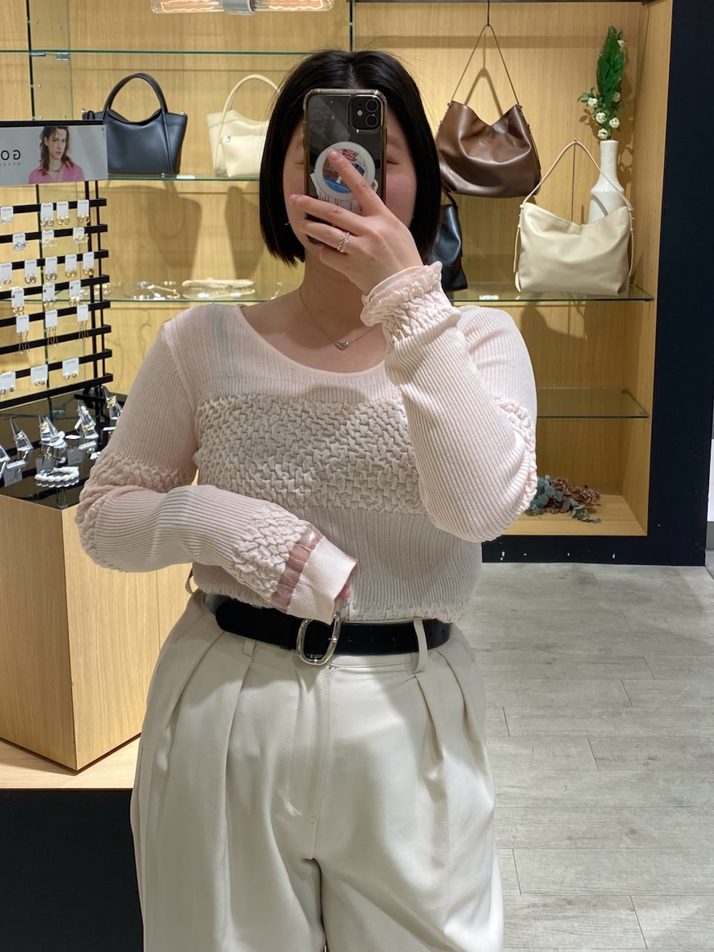 ピンク系のニット/セーター、ホワイト系のその他パンツ、ブラック系のパンプスを着用したレディースの春コーディネートの4枚目の写真