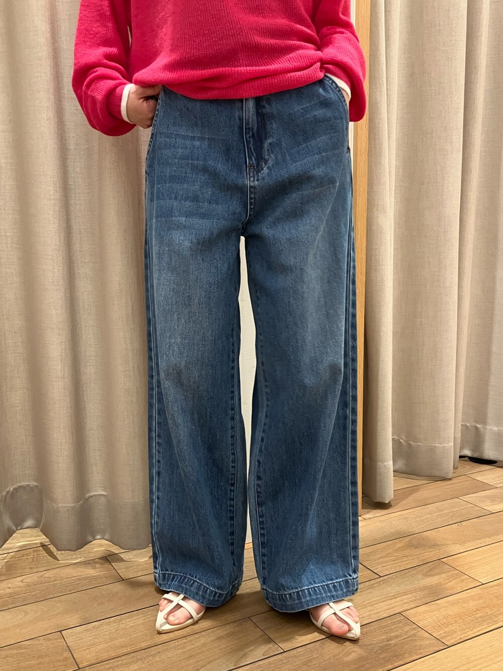 ブルー系のデニムパンツ、ピンク系のニット/セーター、ホワイト系のサンダルを着用したレディースの春コーディネートの5枚目の写真