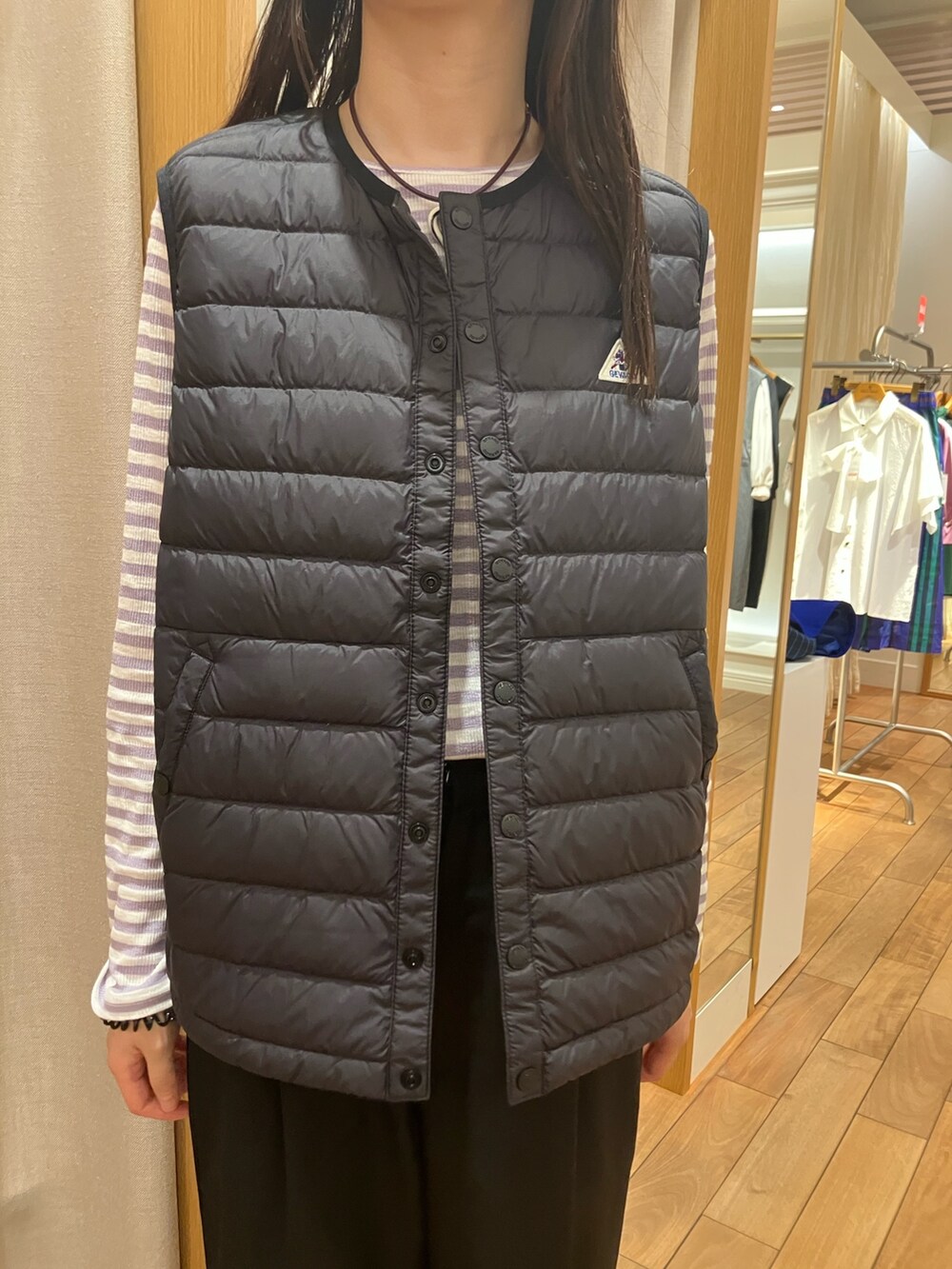 ブルー系のテーラードジャケット、ブラック系のダウンベスト、パープル系のTシャツ/カットソーを着用したレディースの夏コーディネートの6枚目の写真