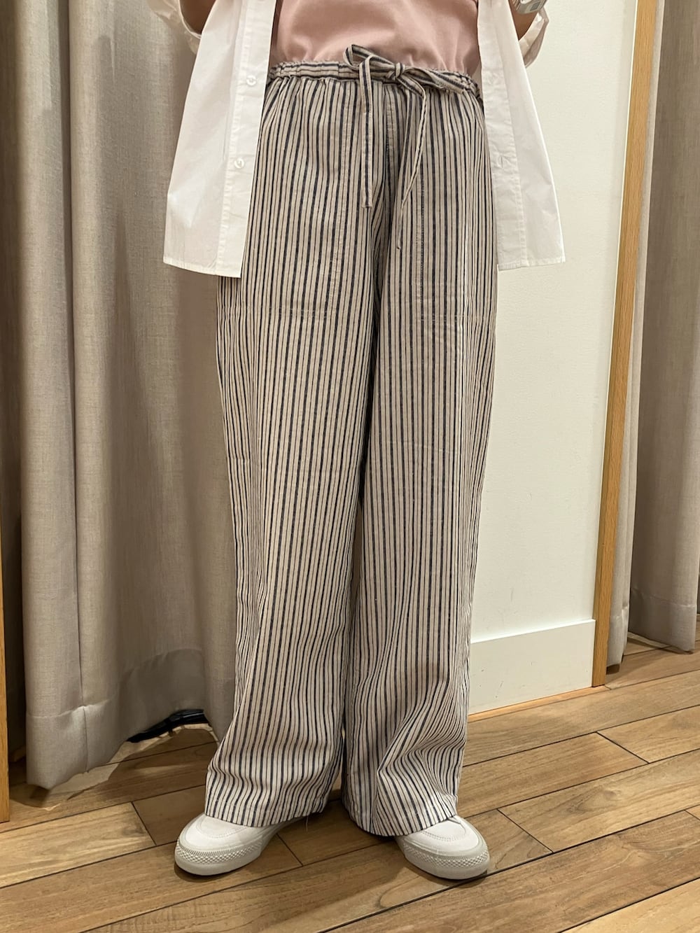 ブルー系のその他パンツ、ピンク系のTシャツ/カットソー、ベージュ系のスニーカーを着用したレディースの春コーディネートの6枚目の写真