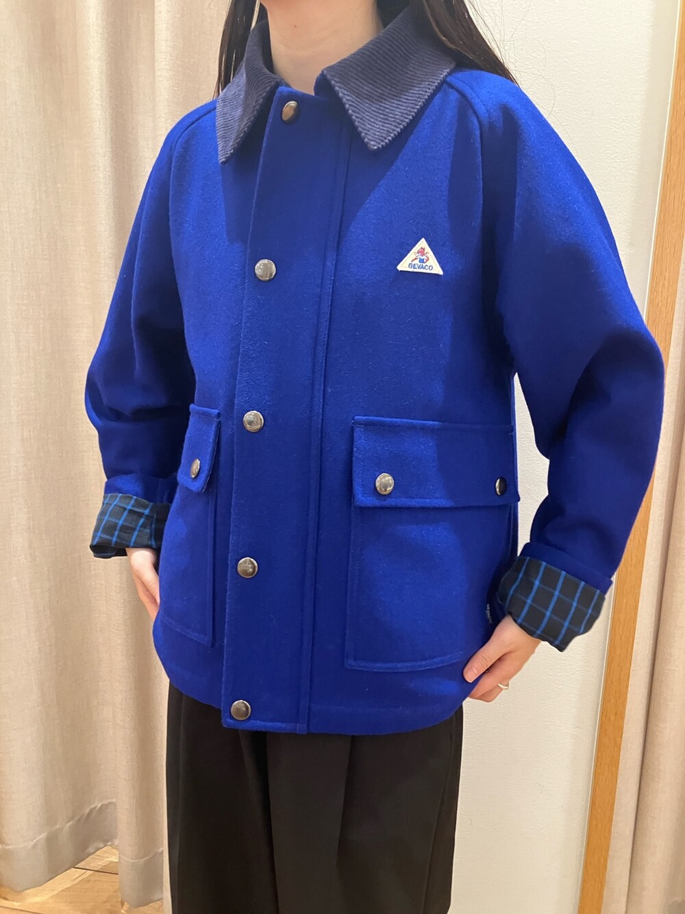 ブルー系のテーラードジャケット、ブラック系のダウンベスト、パープル系のTシャツ/カットソーを着用したレディースの夏コーディネートの4枚目の写真